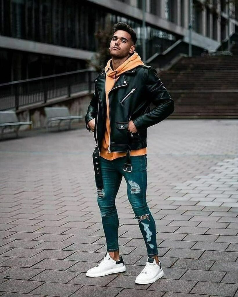 Guy in ripped jeans with a leather biker jacket over a hoodie