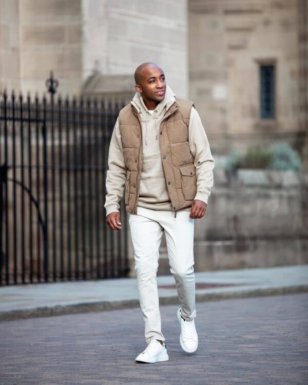  A quilted vest over a hoodie outfit.